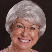 Smiling woman with short white hair and glasses